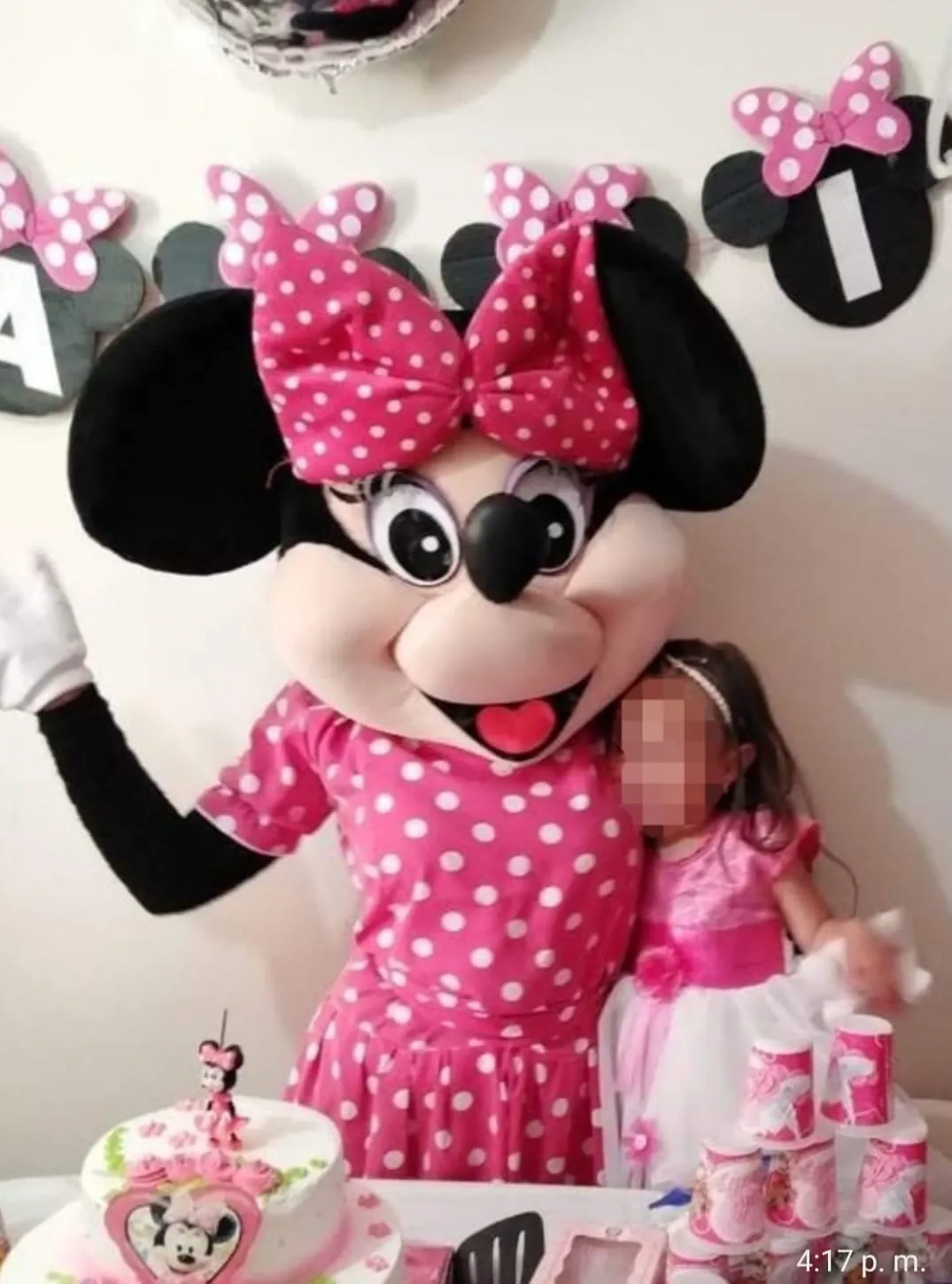 Minnie Mouse junto a una niña en una fiesta temática